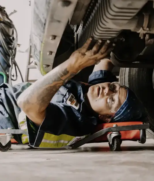 Mechanic performing underbody repair on a commercial truck for LeCoop Truck and Trailer fleet maintenance services