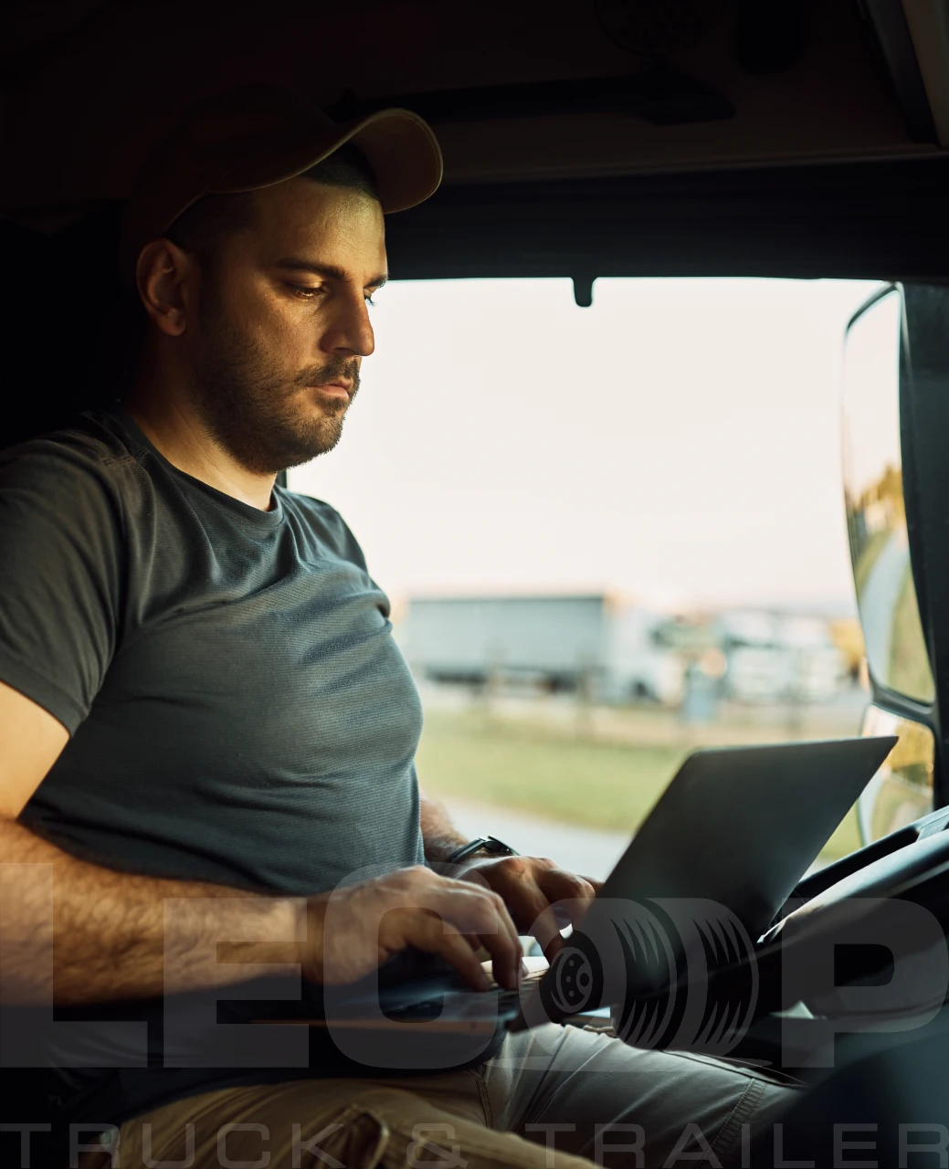 lecoop truck driver using laptop inside cab